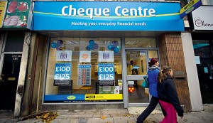 People walk outside a payday loan shop in London, UK. Research suggests that young people under the age of 25 in the UK are twice as likely to turn to companies such as Wonga than talk to their bank account manager or credit card provider when struggling with outgoings